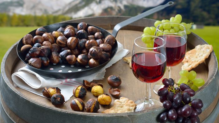 Törggelen mit gerösteten Keschtn und Schüttelbrot, serviert mit jungem Rotwein auf Weinfass.