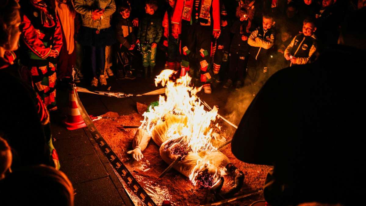 Karnevalisten verfolgen in Köln die Nubbel-Verbrennung. Die Strohpuppe dient symbolisch als Sündenbock für die Vergehen der Menschen im Karneval.