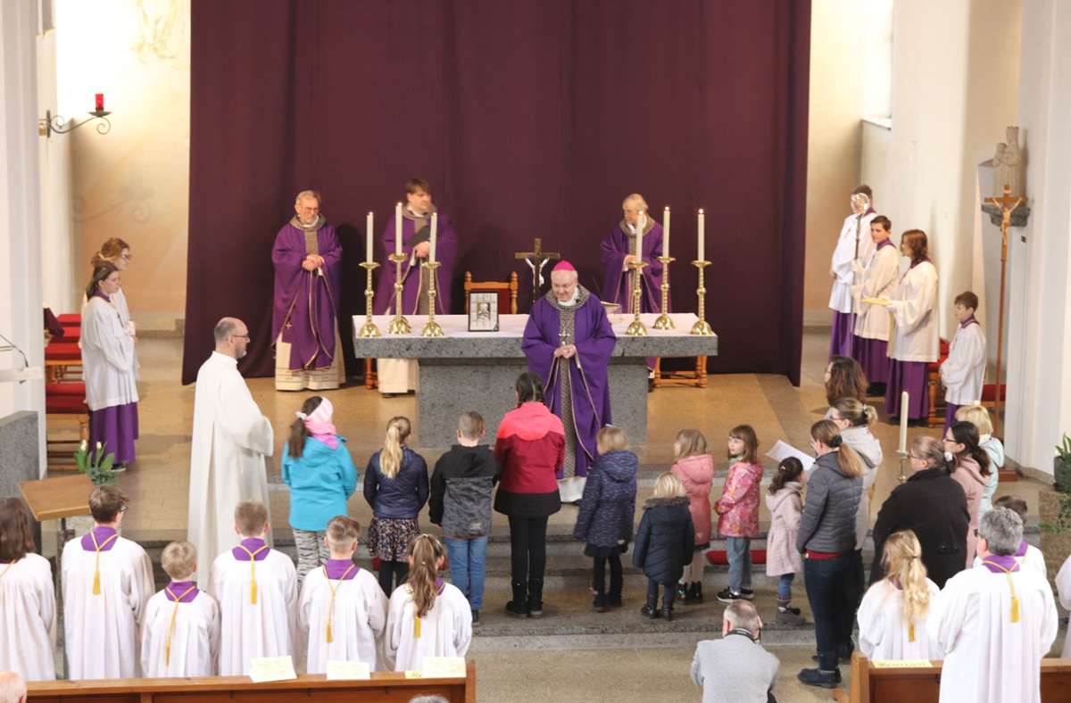 Der Bischof singt mit den Kindern der katholischen  Gemeinde.